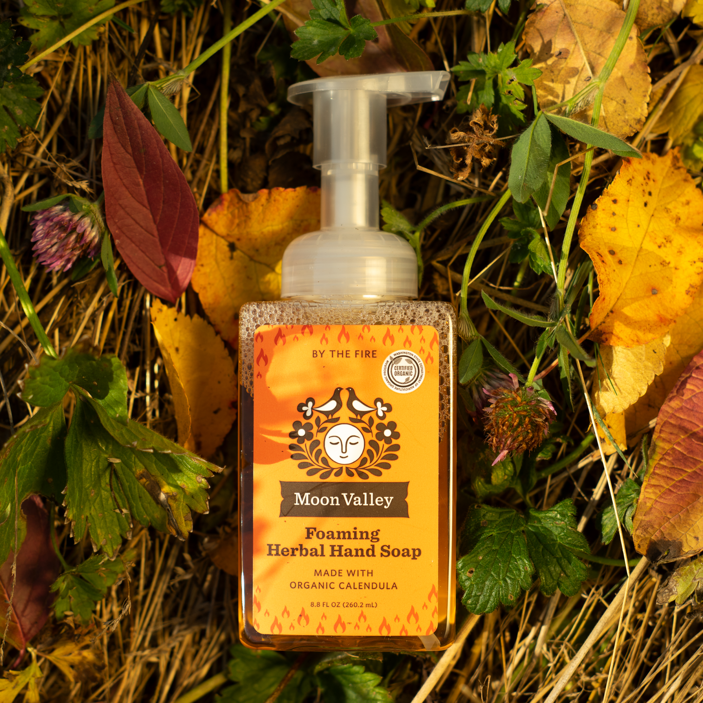 Moon Valley Organics Foaming Herbal Hand Soap Front Dispenser in front of Fall Leaves Background Bottle By The Fire